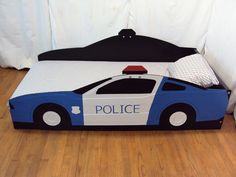 a bed with a police car design on the top and bottom part is made out of cardboard