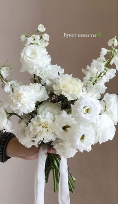 a person holding a bouquet of white flowers