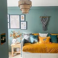 a bedroom with blue walls and yellow bedspread on the bed is decorated with colorful pillows