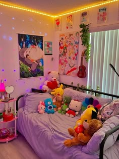 a bed with lots of stuffed animals on top of it in a room filled with lights