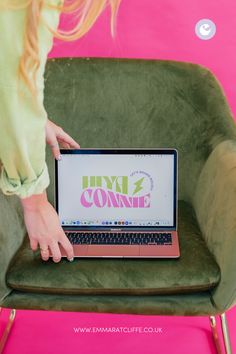 a woman sitting in a green chair with a laptop on her lap and the words hyil connect written on the screen