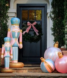 christmas decorations on the front steps of a house, including nutcrackers and ornaments