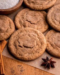 several cookies and anise on top of a wooden table next to cinnamon spicers