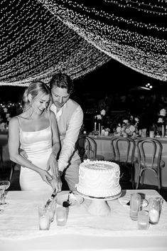 a man and woman cutting a cake together