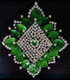 a green and white flower arrangement on a black background