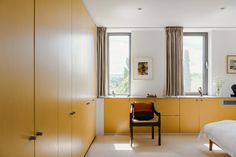 a bedroom with yellow cabinets and a white bed