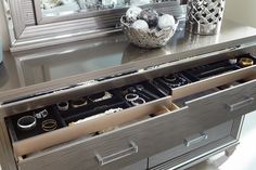 a silver dresser with drawers filled with jewelry