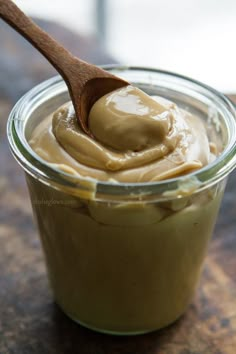 a jar filled with peanut butter and a wooden spoon sticking out of the top one