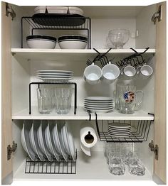 the dishes are organized neatly on the shelves