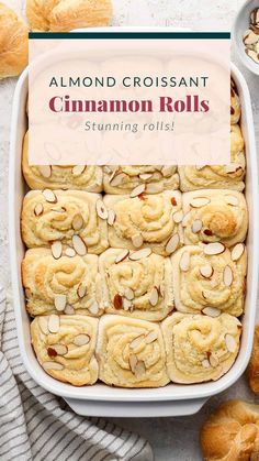 almond croissant cinnamon rolls in a white baking dish with a sign over the top