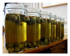 several jars filled with pickles on top of a wooden table