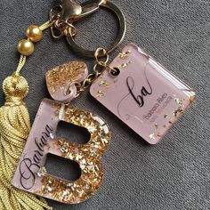 two personalized keychains with the letter b and g on them, one has a tassel attached to it