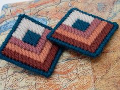 two knitted squares sitting on top of a map