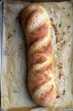 a long piece of bread sitting on top of a pan next to a spatula