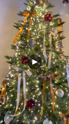 a decorated christmas tree with lights and ornaments on the top is featured in this video