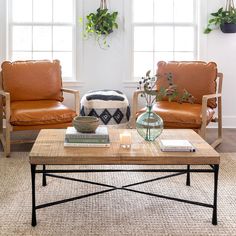 a living room with two leather chairs and a coffee table