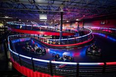 an indoor roller coaster ride with red and blue lights