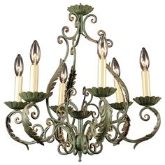 a green chandelier with five lights hanging from it's center and leaves on the bottom