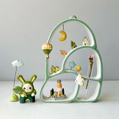 a green and white sculpture sitting next to a small toy rabbit on top of a table