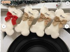 four knitted teddy bears hanging from a christmas tree ornament on a mantle