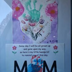 a mother's day card in a window with flowers and handprints on it