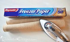 a box of freezer paper next to a roll of fabric and a sewing machine