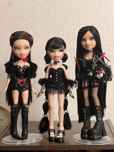 three dolls are dressed in black clothing and boots