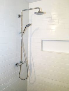 a shower head and hand rail in a bathroom