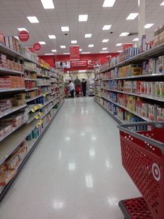 an aisle in a grocery store filled with lots of food and people walking around it