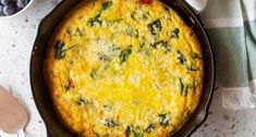 an omelet with spinach and cheese in a cast iron pan on a table