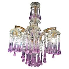 a purple chandelier with three lights hanging from it's sides and two shades of pink