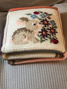 a crocheted blanket sitting on top of a couch