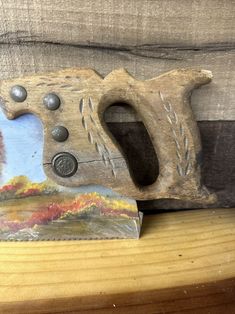 a close up of a piece of wood with a painting on the back of it