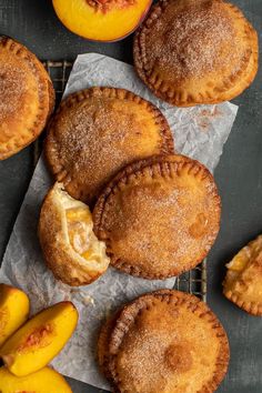 several peach pies on a cooling rack and some sliced peaches