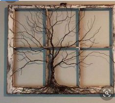 an old window frame with a tree in the middle and four panes on each side