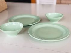 three mint green dishes on a white table