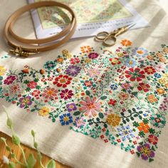 a close up of a table cloth with scissors and other crafting supplies on it