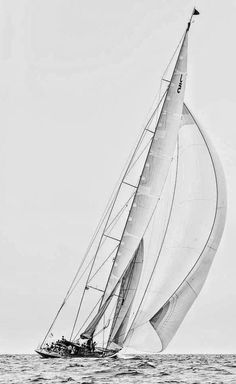 black and white photograph of a sailboat in the ocean