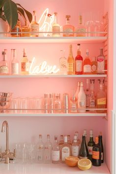 shelves filled with liquor bottles and glasses in a pink bar area that is lit by neon lights