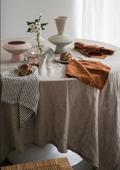 a table topped with a white vase filled with flowers