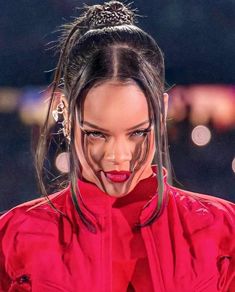 a close up of a person wearing a red shirt and some hair in a bun