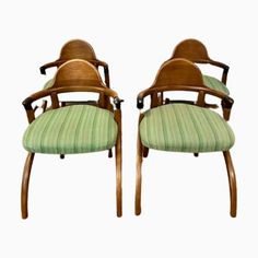 two wooden chairs with green upholstered seats on the back and armrests