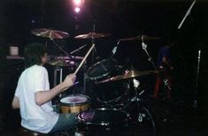 a man sitting in front of a drum set