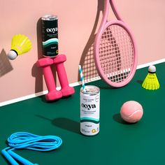 tennis rackets and other sports equipment are on the ground next to a pink wall