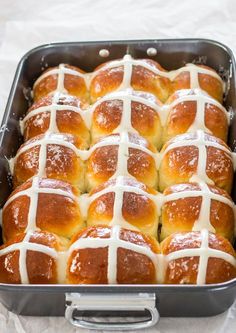 hot cross buns with white icing in a baking pan