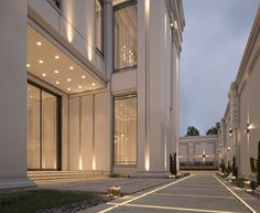 an exterior view of a building with lights on the windows and walkway leading up to it