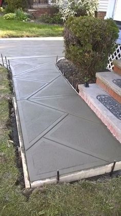 a concrete walkway with steps leading up to the house