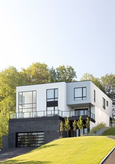 a large white house sitting on top of a lush green hillside