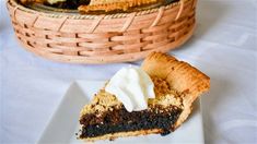 a piece of pie sitting on top of a white plate next to a woven basket