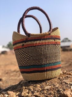 *Our straw U-shopper baskets are handwoven in Bolga Ghana. It can be used as market shopping basket, camping basket, fruit and vegetable storage basket, living space decoration, as natural gift ideas for ladies.  * Its colorful and authentic African designs and high aesthetic value give your living space that lively and natural touch. Care - To reduce shipping costs and other conditions beyond our control during shipping, baskets may be received "crushed." - To regain the perfect basket stature, Daily Use Straw Basket Bag With Top Carry Handle, Daily Use Basket Straw Bag With Top Carry Handle, Brown Bucket Bag For Market, Shopping Bucket Straw Bag With Rolled Handles, Brown Basket-shaped Straw Bag With Top Carry Handle, Brown Basket Shaped Straw Bag With Top Carry Handle, Top Handle Bags With Rolled Handles For Market, Woven Basket Bucket Bag For Shopping, Woven Basket-shaped Bucket Bag For Shopping